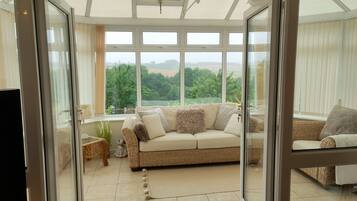 A spacious living room with a large window, a sofa, and a television.