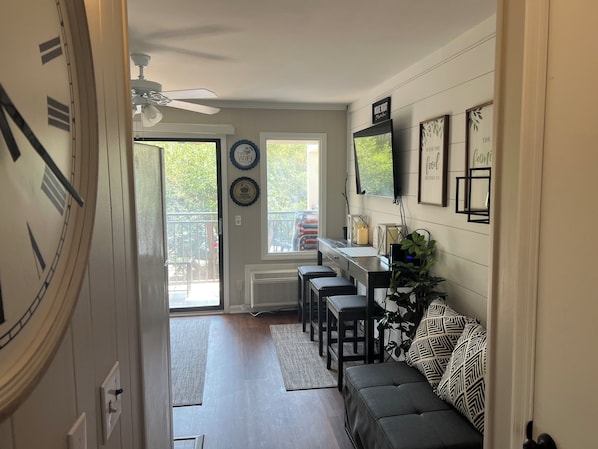 A modern kitchen with a dining area, a ceiling fan, a TV, and a clock. - Cheerful 3 beds ocean View condo walking to the beach distance.Permit # 073566 (Hilton Head Island)