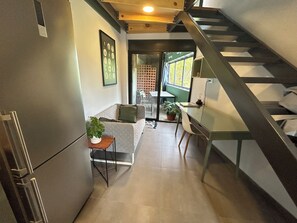 Eine moderne Küche mit Einbauherd, ein Essbereich mit Tisch und Stühlen sowie eine Treppe zu einer oberen Ebene.
