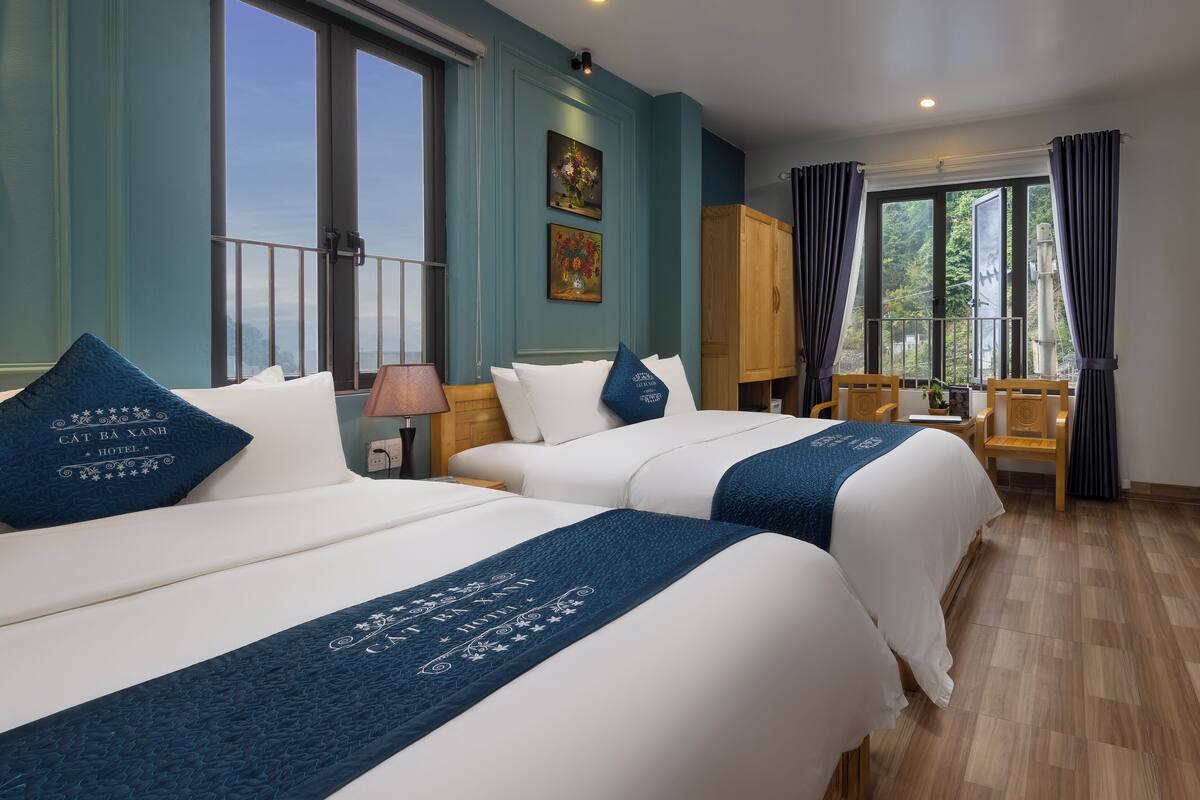 Ein Hotelzimmer mit zwei Betten, einem Balkon und Blick ins Freie.