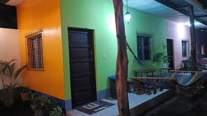 A colorful exterior with a black door, a hammock, and potted plants. - Hostel Coco's (Moyagalpa)