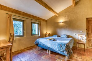A bedroom with a bed, two windows, a wooden chair, a desk, and a wardrobe. - Spacious villa with 25 m pool and spa, mountain view, 20 min from Montpellier (St Mathieu de Tréviers)
