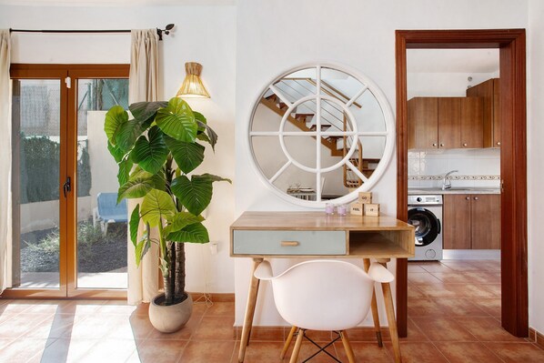 Une cuisine moderne avec des meubles en bois, un lave-linge et un coin repas comprenant une table et des chaises.