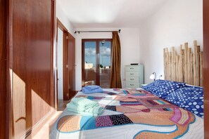 Une chambre à coucher avec un lit, une commode, une fenêtre avec des rideaux et une vue sur le ciel.