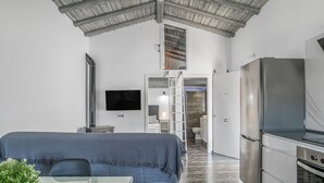 Eine moderne Küche mit Kühlschrank, Backofen und einem Essbereich mit Tisch und Stühlen.