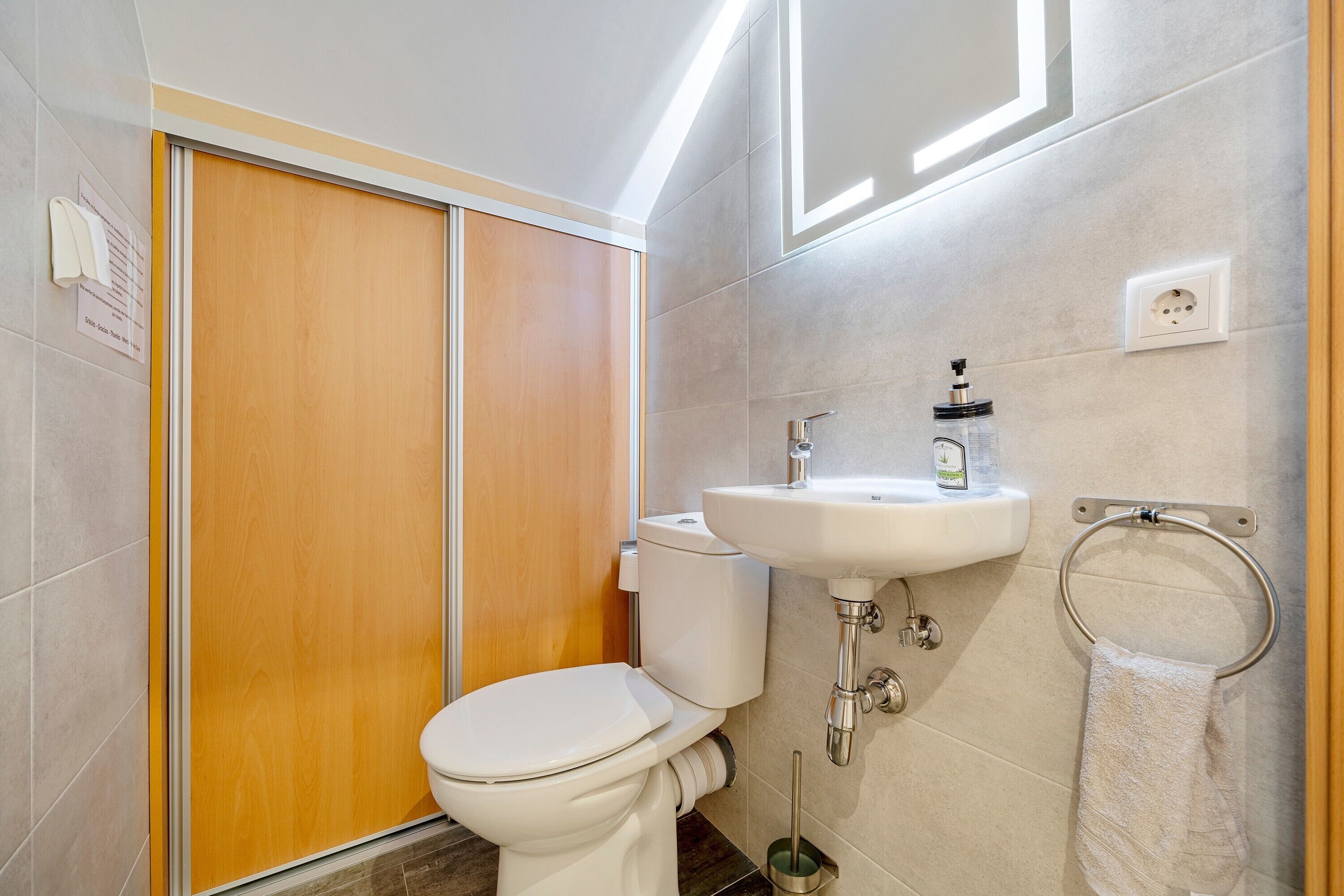 A bathroom with a toilet, sink, and towel rack.