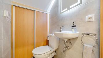 Baño con inodoro, lavamanos y toallero.