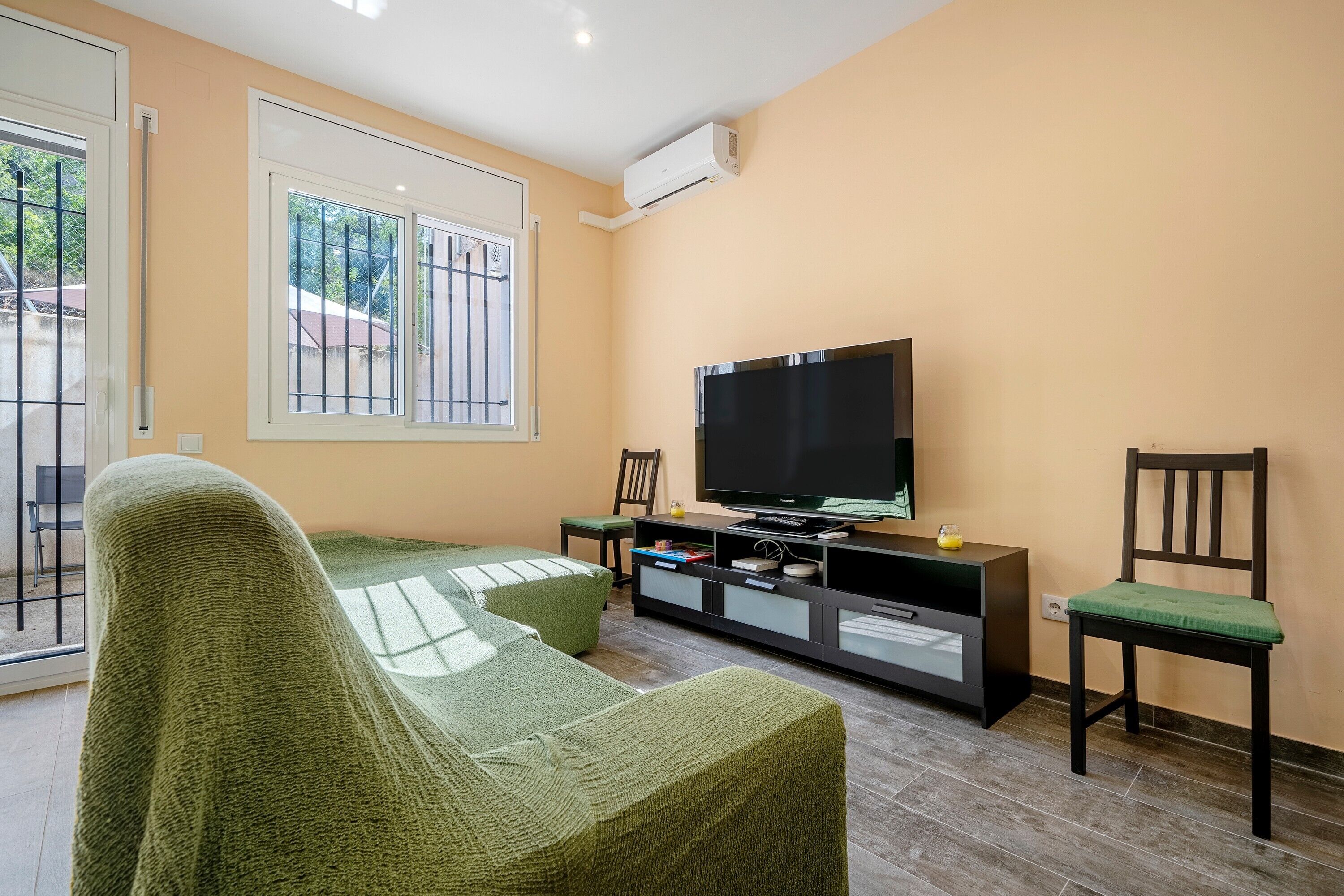 A living room with a sofa, a TV, a cabinet, and a chair.