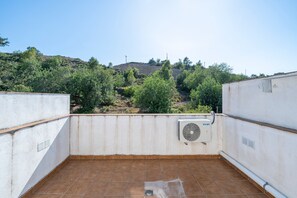 A rooftop terrace with a white air conditioning unit, a view of a hilly landscape, and a clear sky. - Holiday Home 'Casa Lluma' with Mountain View, Wi-Fi and Air Conditioning (Aldover)