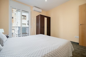 A bedroom with a bed, a wardrobe, a balcony with a railing, and an air conditioning unit. - Holiday Home 'Casa Lluma' with Mountain View, Wi-Fi and Air Conditioning (Aldover)