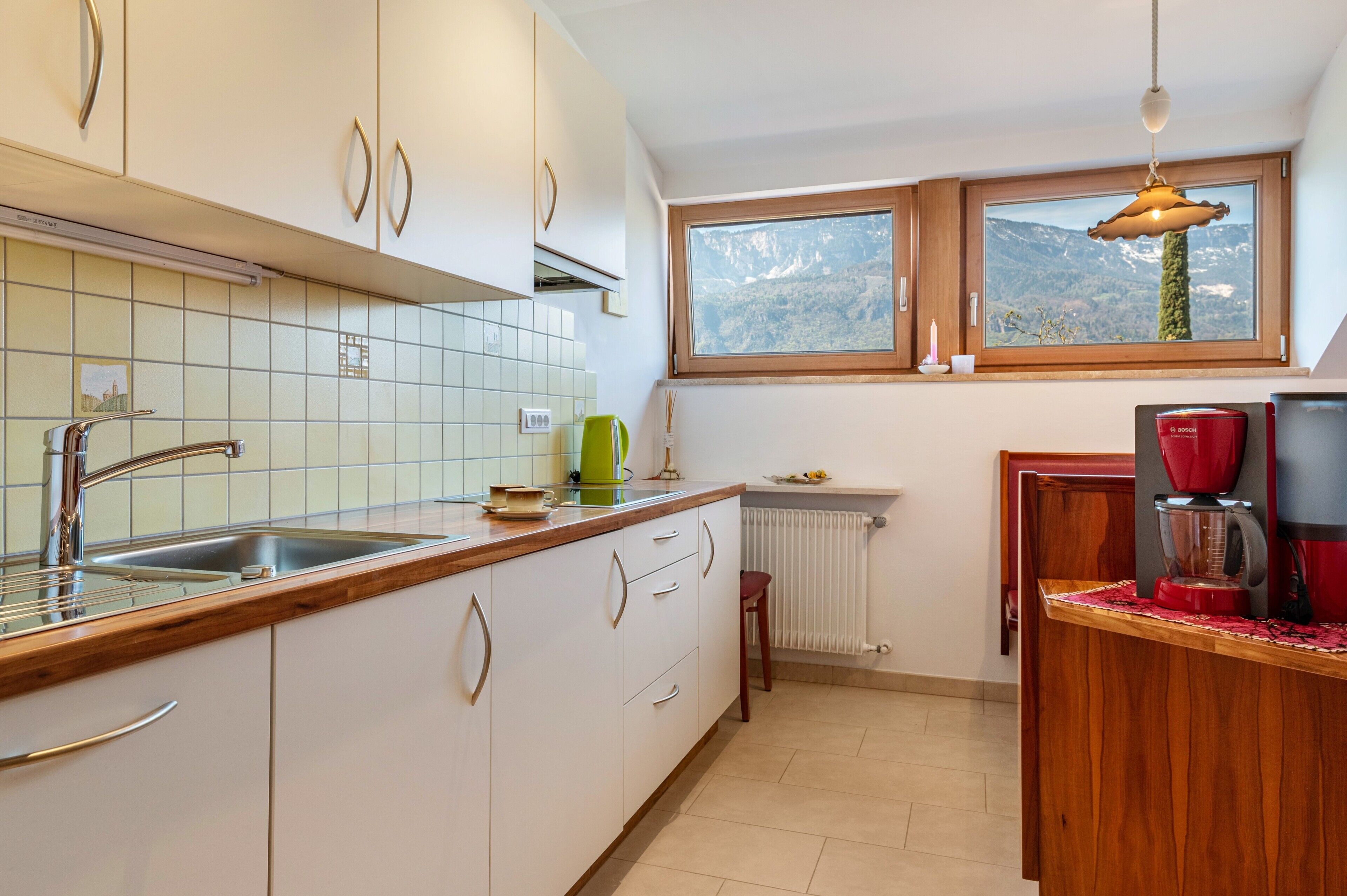 Eine Küche mit Fenster, Spüle, Schränken und einer Arbeitsplatte.