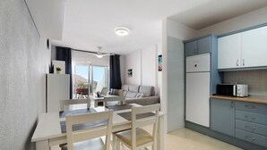 A modern kitchen with a dining area, a refrigerator, a microwave, and a view to the outside. - Vacation Apartment 'Isabel Vista Sur' with Sea View, Shared Pool and Wi-Fi (Chayofa)