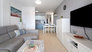 A modern living room with a sofa, coffee table, and TV stand. - Vacation Apartment 'Isabel Vista Sur' with Sea View, Shared Pool and Wi-Fi (Chayofa)
