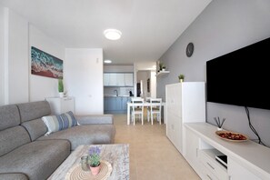 Ein modernes Wohnzimmer mit einer Couch, einem Couchtisch und einem TV-Schrank.
