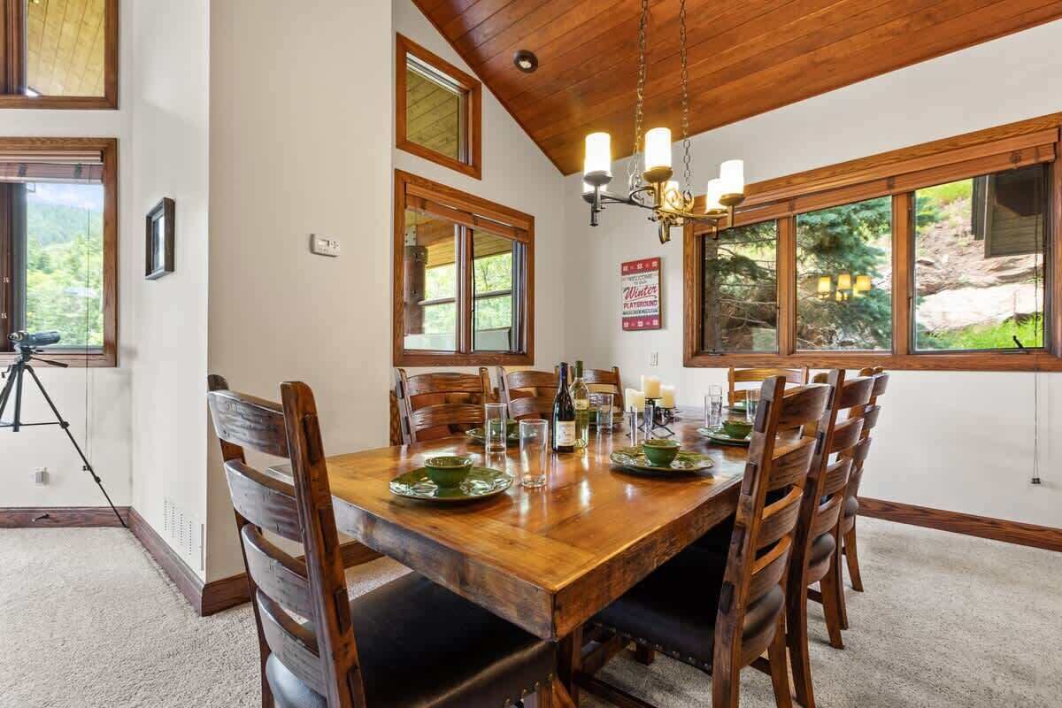 Un coin repas avec une table en bois, des chaises et un lustre.