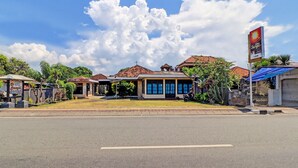 A hotel with a large sign, a well-maintained lawn, and a clear sky. - SPOT ON 92028 Hotel Surya Near Pelabuhan Gilimanuk (Melaya)