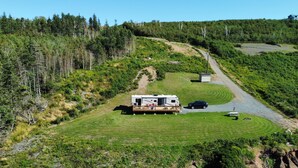 Een campercamping met een caravan, een kleine schuur en een verhard pad.