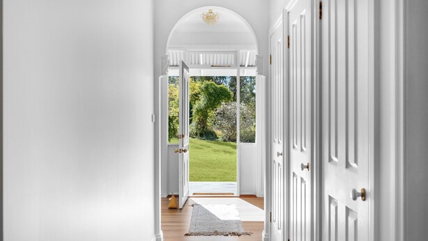 A hallway with white doors leading to a glass door opening to a garden. - Hygge House - Kangaroo valley (Kangaroo Valley)