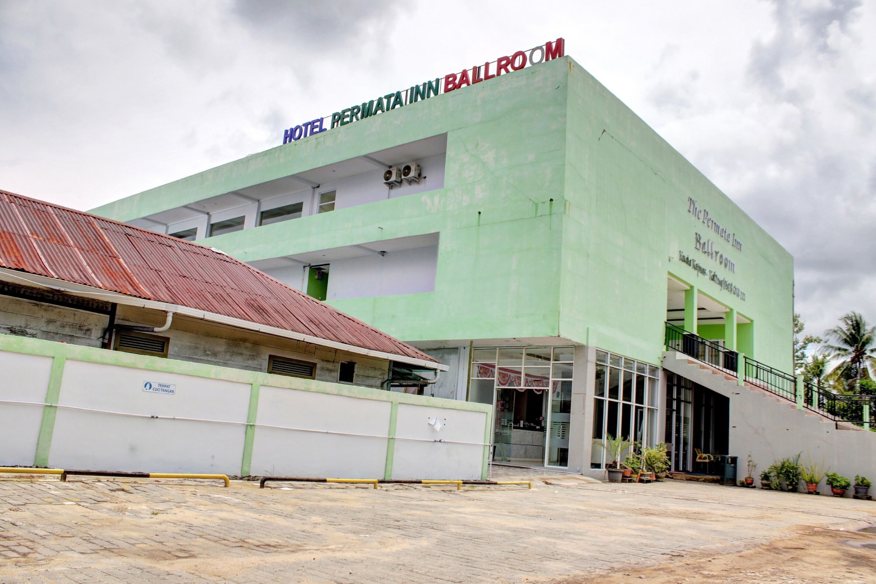 A hotel with a green facade, a red roof, and a sign indicating a ballroom.