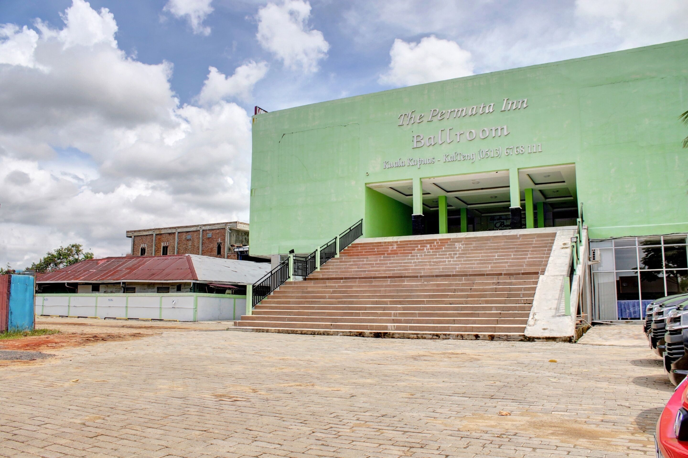 A building with a green facade and a sign reading "The Permata Inn Ballroom."