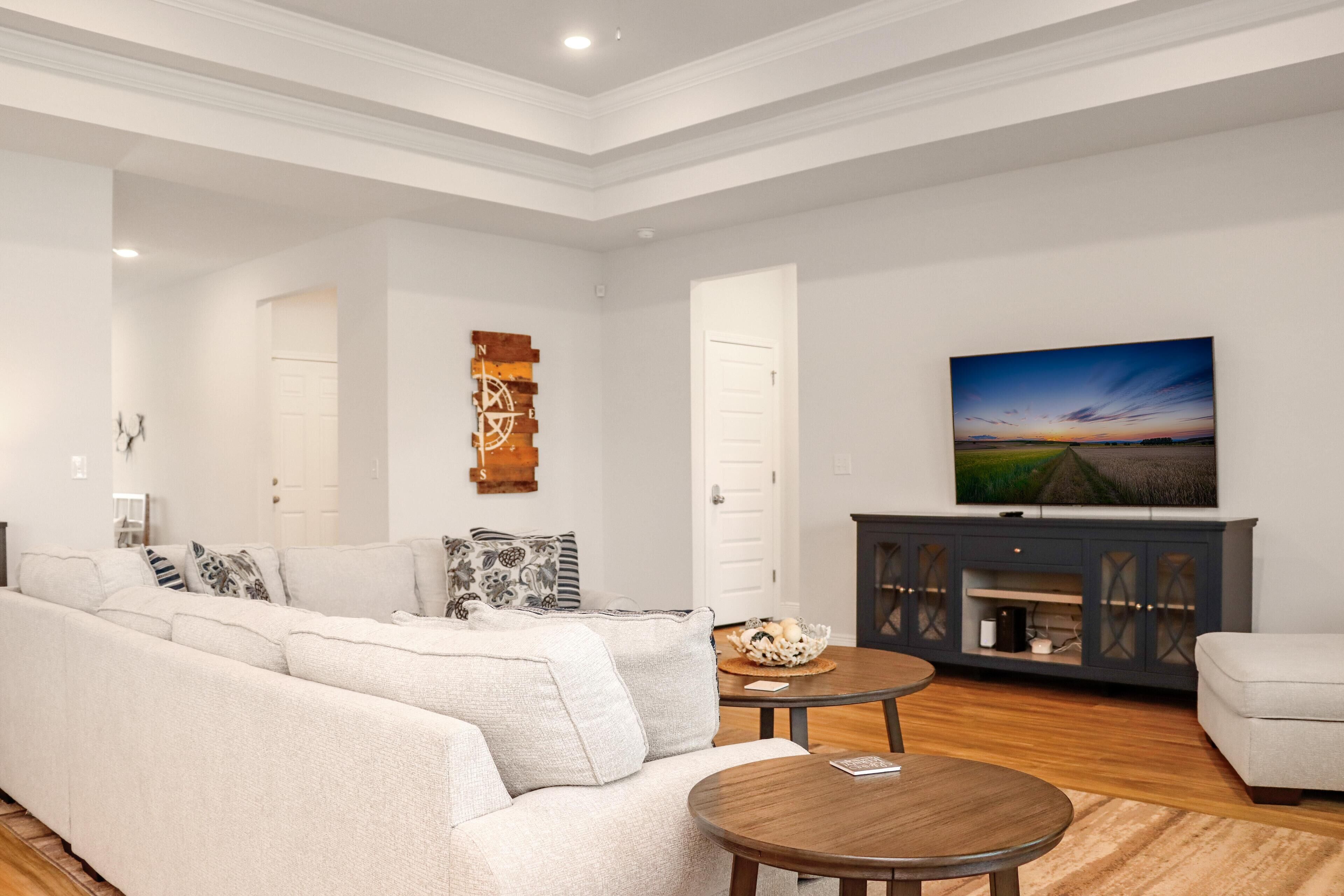 A modern living room with a sofa, a coffee table, and a television on a cabinet.