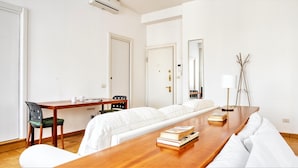 Une chambre d’hôtel comprenant une table à manger en bois, un canapé, une chaise, un lit, un bureau et une lampe.