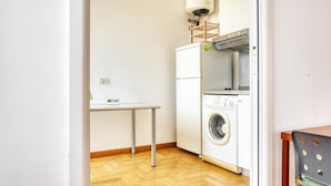 Une petite buanderie comprenant un lave-linge, un sèche-linge et une petite table.