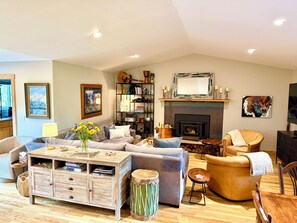A living room with a fireplace, a sofa, a coffee table, and a bookshelf.