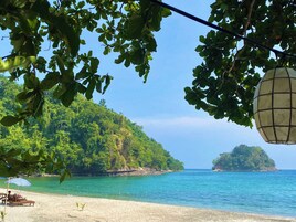 Praia particular, espreguiçadeiras, prática de vôlei de praia