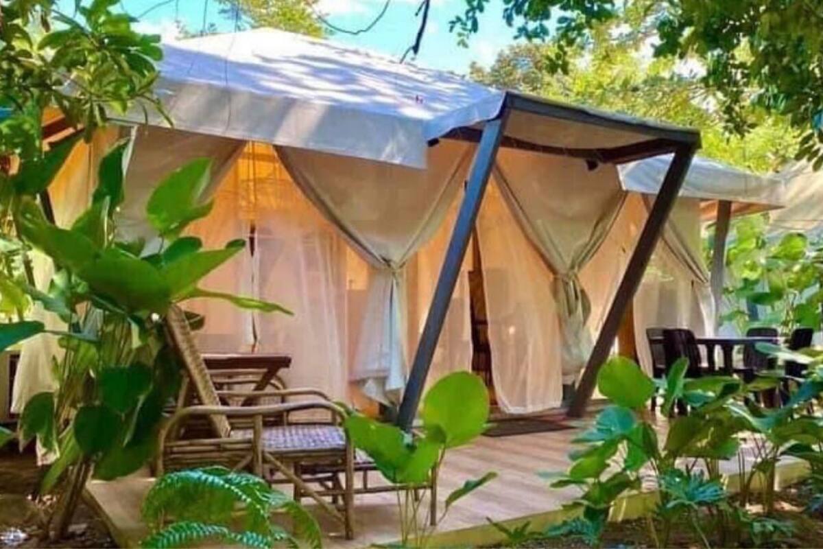 A tent with a covered patio area, a table, and chairs.