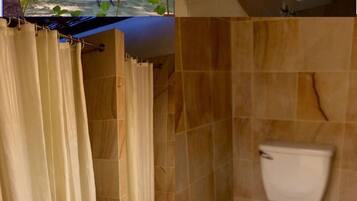 A bathroom with a toilet, sink, and shower curtain.
