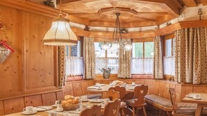 A wooden dining area with a large table, chairs, and a hanging light fixture. - Rustic Tyrolean guesthouse, only 300m from the ski lift (Scheffau am Wilden Kaiser)