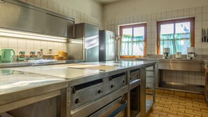 A modern kitchen with stainless steel appliances, a large island, and a window with curtains. - Rustic Tyrolean guesthouse, only 300m from the ski lift (Scheffau am Wilden Kaiser)