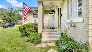 A single-story house with a front porch, a flag, and a mailbox labeled "150 A". - Charming Midtown Apt - Hannon Hideaway Unit A (Mobile)