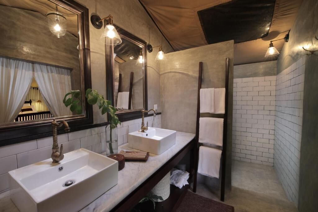 Casa de banho com duas pias, um espelho grande e zona de duche.