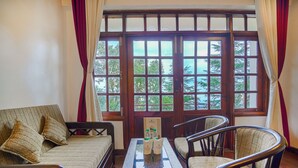 A room with a sofa, two chairs, a table with bottles, and a large window with curtains. - Pax Ark Dalhousie (Dalhousie)