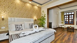 A spacious bedroom with a large bed, a wooden floor, and a decorative wall. - Pax Ark Dalhousie (Dalhousie)