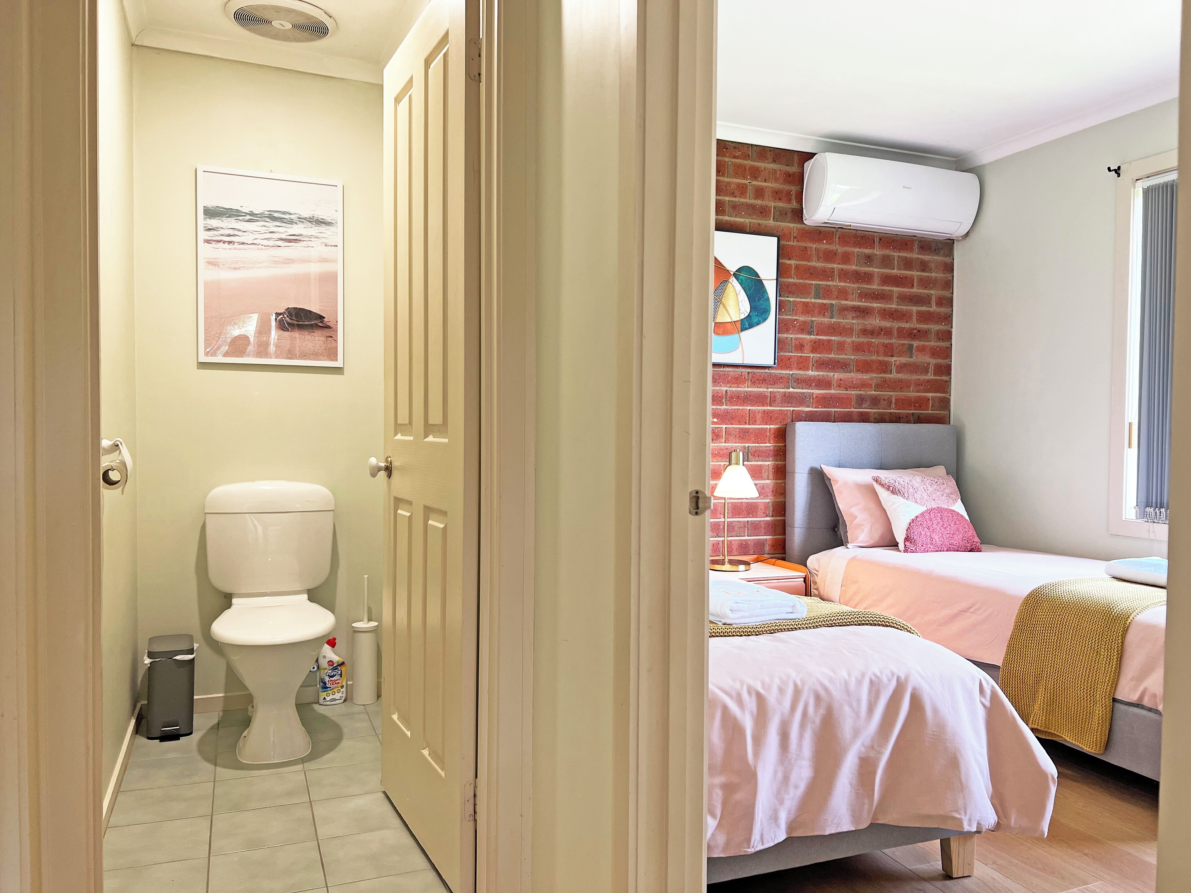 A bedroom with a bed, a bedside table, and a window.