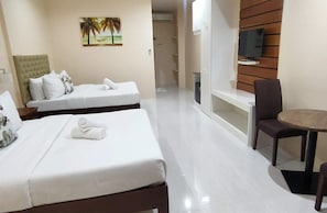 Une chambre d’hôtel avec deux lits, une télévision, un bureau et une chaise.