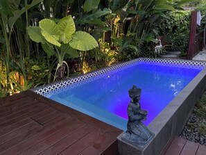 Relax by the serene pool surrounded by lush tropical foliage and a decorative tile edge.