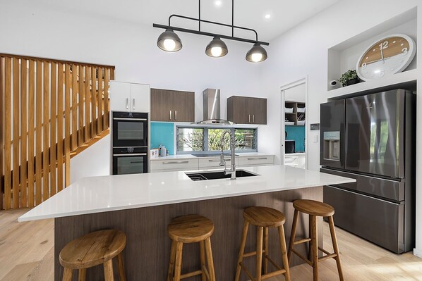 Enjoy cooking in this spacious kitchen with a large island, sink, and bar stools.