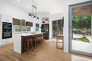 Enjoy cooking in this well-equipped kitchen with a large island, sink, oven, refrigerator, and dishwasher.