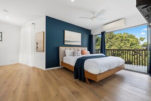 Relax in a spacious bedroom with a large bed, ceiling fan, and balcony view.