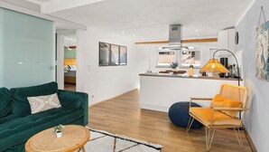 A modern living room with a green sofa, a round coffee table, and a blue bean bag. - Tucan - Rooftop Terrace With View, Bbq, Ps4+streaming (Marburg)