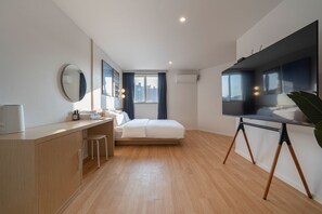 Un dormitorio moderno con cama, mesita de noche y un amplio ventanal.