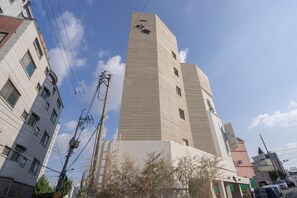 Un edificio alto y moderno de forma rectangular y techo plano.