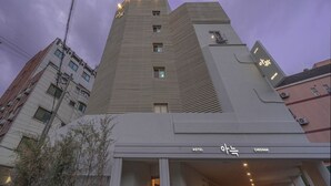 Un hotel moderno con un ingresso ben visibile, diversi piani e un design architettonico distintivo.