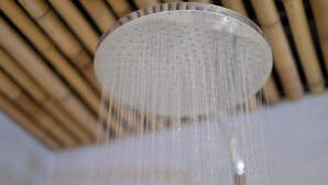 Un cabezal de ducha con agua corriendo.