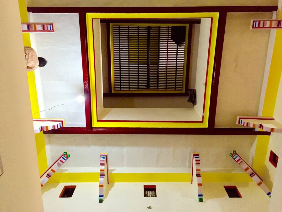 A room with a window, a door, and a small window on the wall.