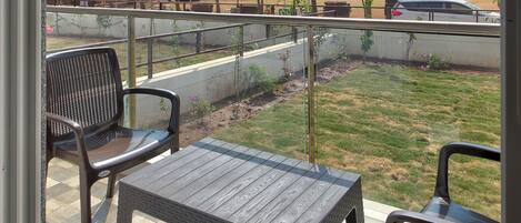 A covered patio area with a view of a park and distant buildings.